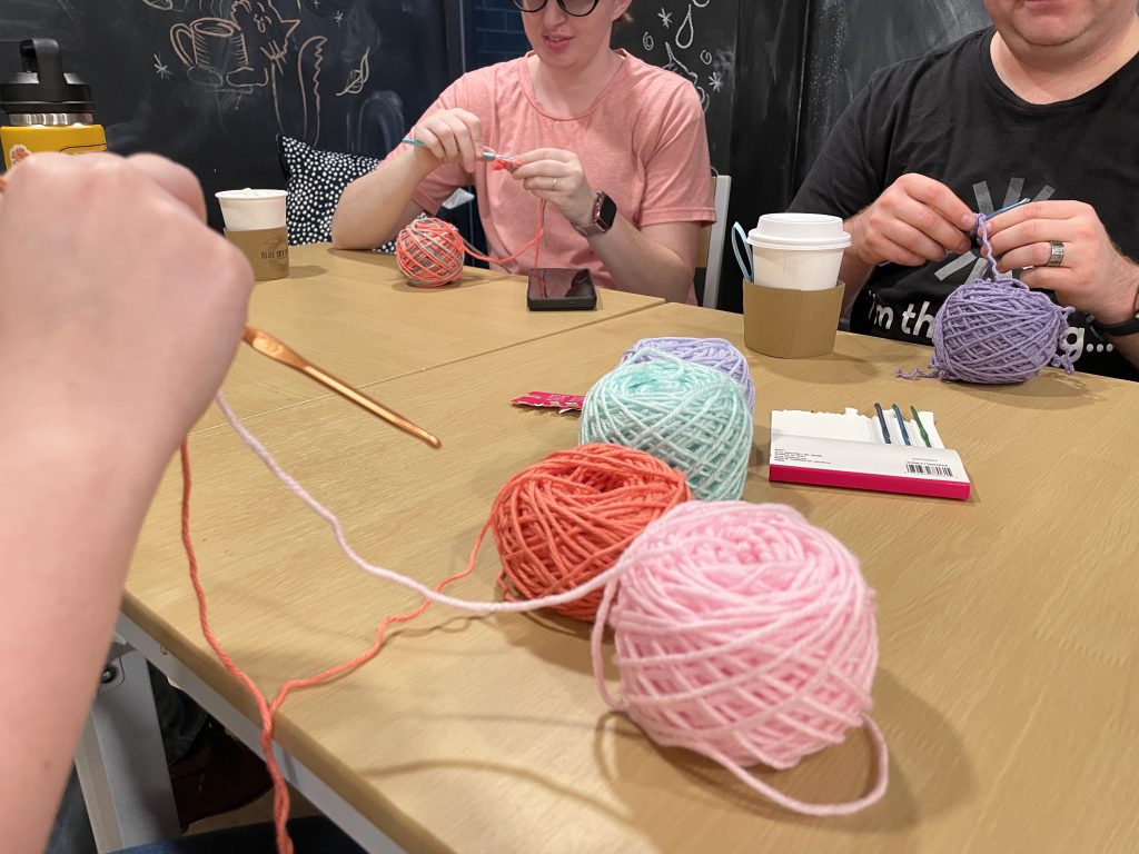 Image of attendees learning to crochet at Blue Sky Coffee's Sip & Stitch event