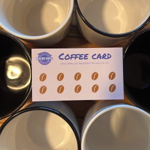 Blue Sky Coffee's "coffee punch card" sitting atop a circle of mugs